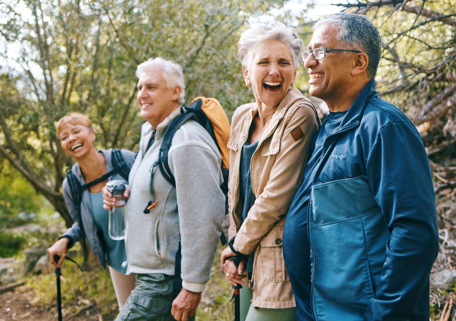 A group of smiling seniors enjoying a hike together.