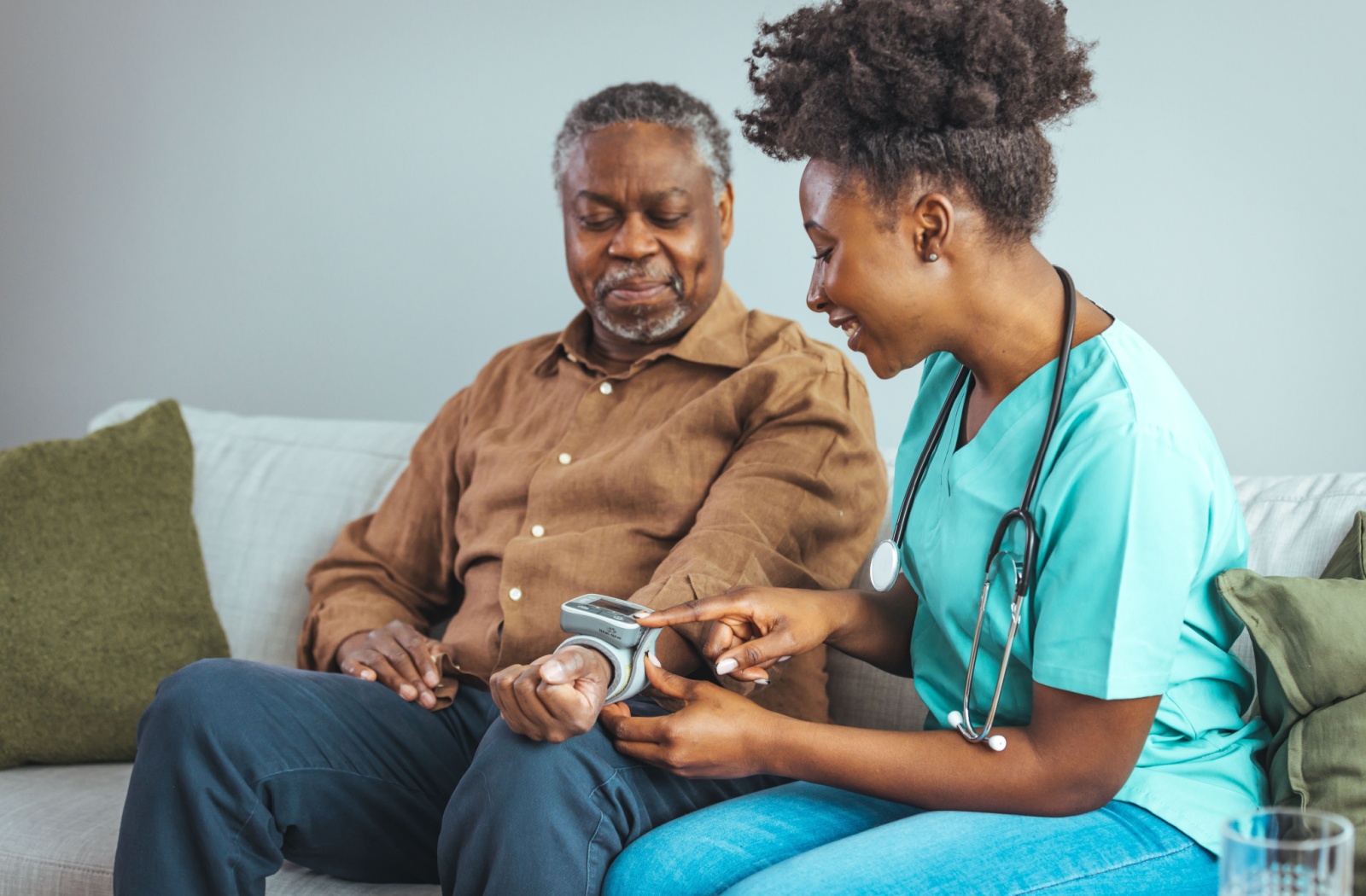 An assisted living associate helps a resident take their blood pressure reading.