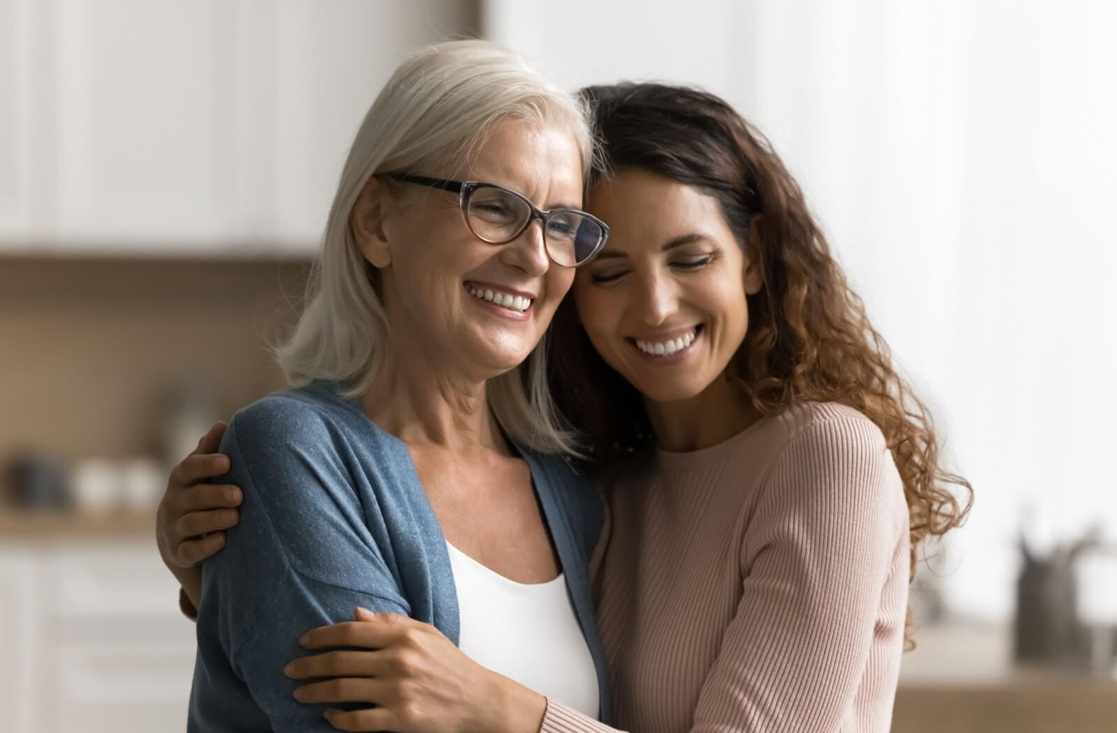 Smiling parent and adult child hugging closely showing warmth and support during assisted living discussion
